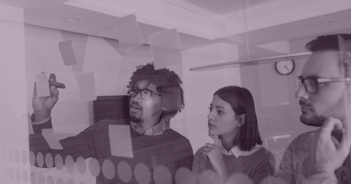 Marketing team planning a business strategy using sticky notes during a collaborative workshop.