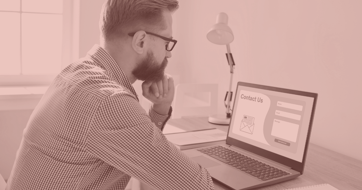 Marketer reviewing a PPC landing page with a contact form on a laptop.